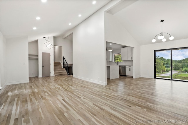 2936 E 75th St, Tulsa, OK 74136 - unfurnished living room featuring plenty of natural light, light wood-type flooring, stairs, recessed lighting, and high vaulted ceiling
