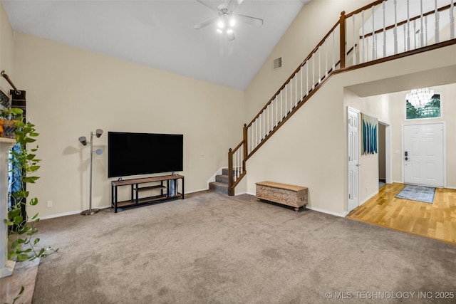 7416 S 109th E Ave, Tulsa, OK 74133 - unfurnished living room with carpet flooring, stairway, high vaulted ceiling, ceiling fan, and a chandelier