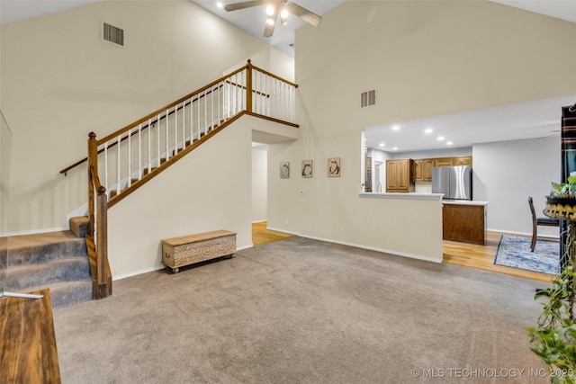 7416 S 109th E Ave, Tulsa, OK 74133 - unfurnished living room with light carpet, stairs, ceiling fan, high vaulted ceiling, and recessed lighting