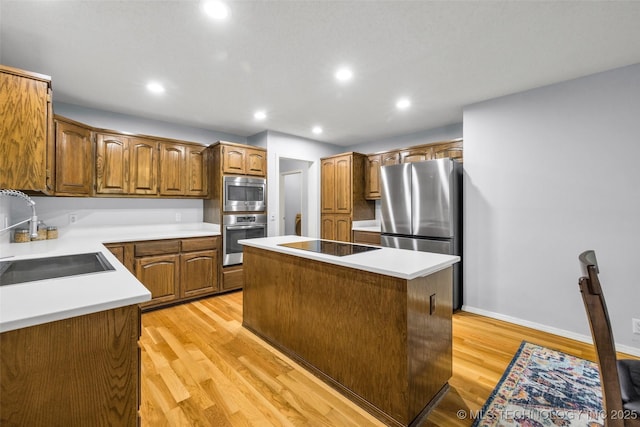 7416 S 109th E Ave, Tulsa, OK 74133 - kitchen with appliances with stainless steel finishes, a kitchen island, light wood-type flooring, recessed lighting, and brown cabinets