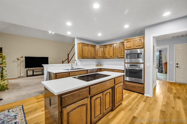 7416 S 109th E Ave, Tulsa, OK 74133 - kitchen with stainless steel appliances, light countertops, brown cabinets, a center island, and recessed lighting