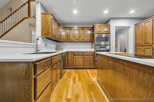 7416 S 109th E Ave, Tulsa, OK 74133 - kitchen featuring stainless steel appliances, light wood-type flooring, brown cabinetry, light countertops, and recessed lighting