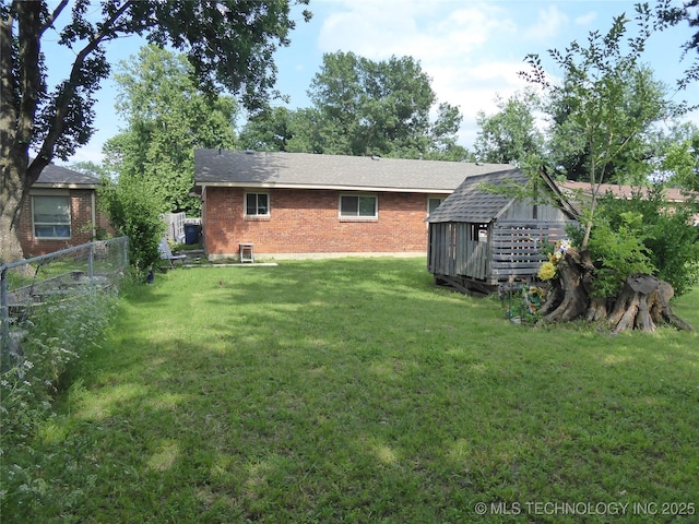 2414 S 126th E Ave, Tulsa, OK 74129 - rear view of house with brick siding, a storage unit, and a shingled roof