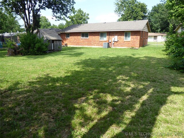 2414 S 126th E Ave, Tulsa, OK 74129 - back of house featuring a yard, a storage unit, and brick siding