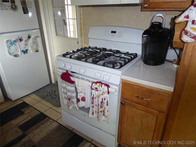 2414 S 126th E Ave, Tulsa, OK 74129 - kitchen featuring white appliances, brown cabinets, light countertops, exhaust hood, and light tile patterned floors