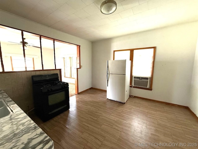 903 W Broadway St, Henryetta, OK 74437 - kitchen featuring black gas range, freestanding refrigerator, cooling unit, and light countertops