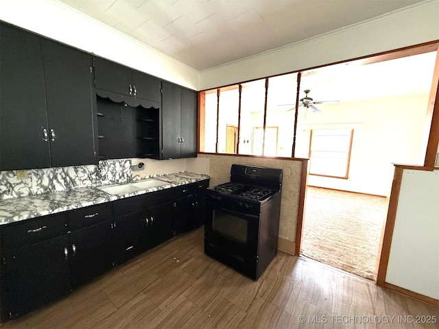 903 W Broadway St, Henryetta, OK 74437 - kitchen with black range with gas stovetop, dark cabinets, crown molding, light countertops, and a ceiling fan