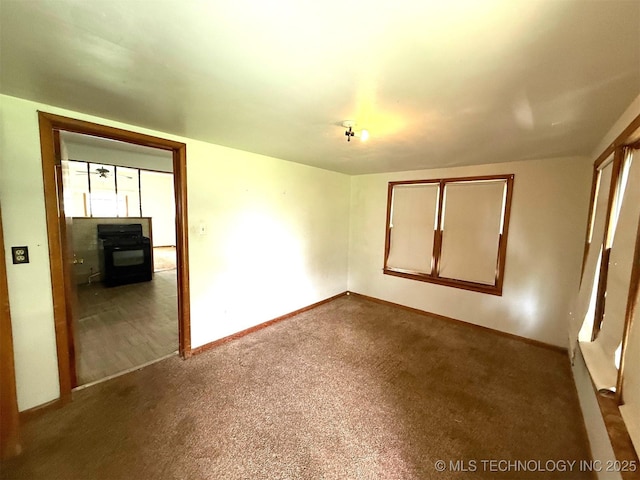 903 W Broadway St, Henryetta, OK 74437 - spare room with baseboards and dark carpet