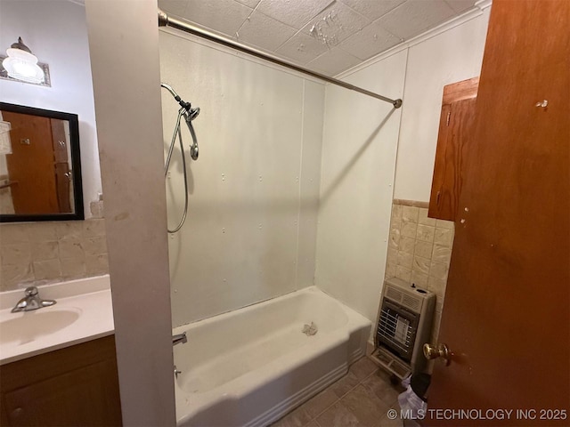 903 W Broadway St, Henryetta, OK 74437 - full bathroom featuring tile walls, heating unit, bathing tub / shower combination, tile patterned flooring, and vanity