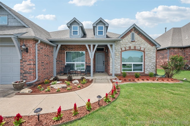 14220 S Vandalia Ave, Bixby, OK 74008 - view of front facade with a front yard, brick siding, a garage, stone siding, and a shingled roof