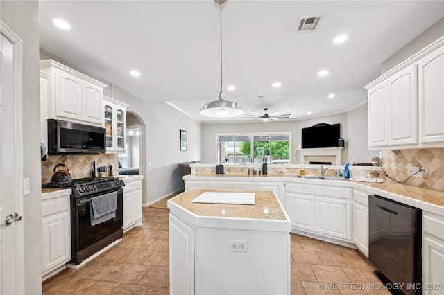 14220 S Vandalia Ave, Bixby, OK 74008 - kitchen with stainless steel microwave, black gas range, dishwasher, a ceiling fan, and a peninsula