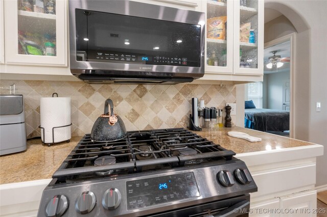 14220 S Vandalia Ave, Bixby, OK 74008 - kitchen with appliances with stainless steel finishes, light countertops, backsplash, and white cabinets