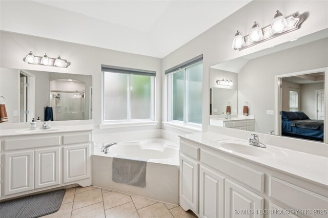 14220 S Vandalia Ave, Bixby, OK 74008 - full bathroom featuring a stall shower, healthy amount of natural light, two vanities, and a garden tub