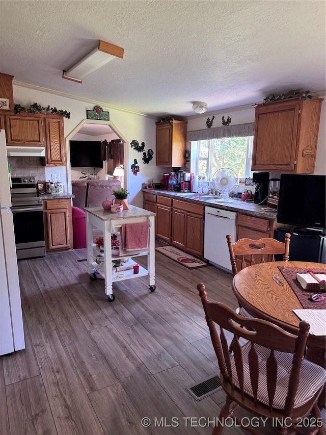 2399 County Road 1405, Skiatook, OK 74070 - kitchen with white dishwasher, stainless steel electric range oven, a textured ceiling, brown cabinets, and dark wood finished floors