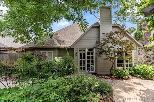 243 E 27th Pl, Tulsa, OK 74114 - back of house featuring a chimney and roof with shingles