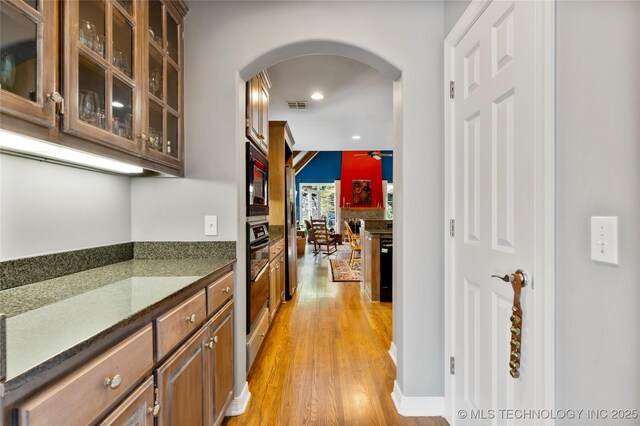 243 E 27th Pl, Tulsa, OK 74114 - hall featuring arched walkways, light wood-style flooring, and recessed lighting