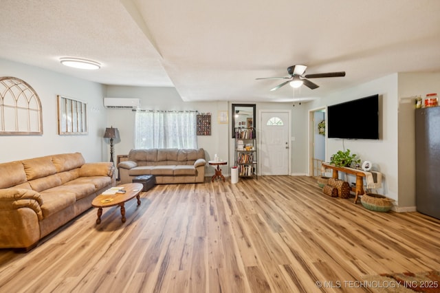 705 S E St, Skiatook, OK 74070 - living area with a wall unit AC, wood finished floors, and a ceiling fan