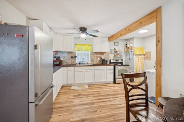 705 S E St, Skiatook, OK 74070 - kitchen featuring freestanding refrigerator, electric stove, ceiling fan, light wood finished floors, and white cabinetry