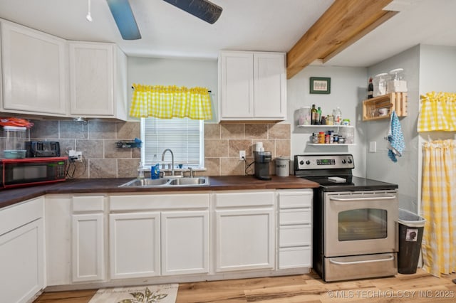 705 S E St, Skiatook, OK 74070 - kitchen with stainless steel electric stove, black microwave, dark countertops, white cabinetry, and backsplash