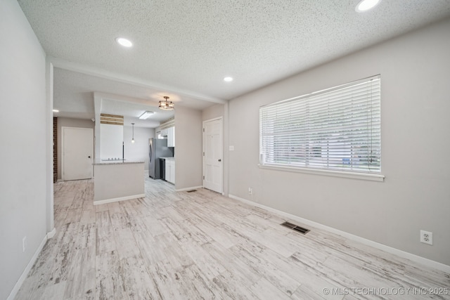 148 E 57th St, Tulsa, OK 74105 - unfurnished living room with recessed lighting, a textured ceiling, and light wood finished floors