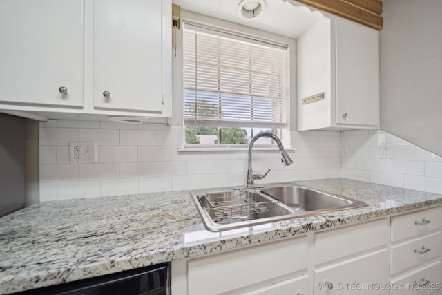 148 E 57th St, Tulsa, OK 74105 - kitchen with white cabinetry, decorative backsplash, dishwashing machine, and light stone countertops