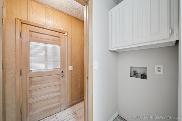 148 E 57th St, Tulsa, OK 74105 - laundry area featuring cabinet space, hookup for a washing machine, wooden walls, and light wood-style floors