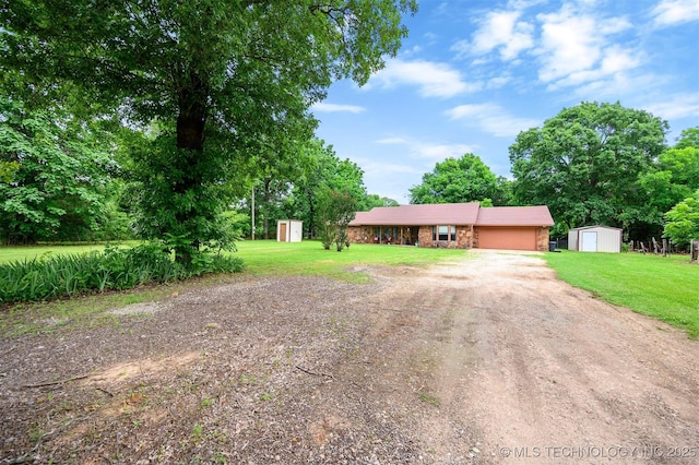 1001 E 1990th Rd, Soper, OK 74759 - view of front of property featuring a storage unit, dirt driveway, a garage, and a front yard