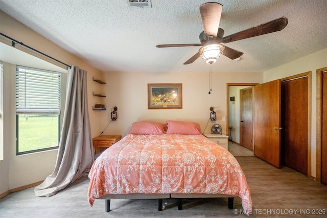 1001 E 1990th Rd, Soper, OK 74759 - bedroom featuring a textured ceiling, light wood-style floors, and ceiling fan