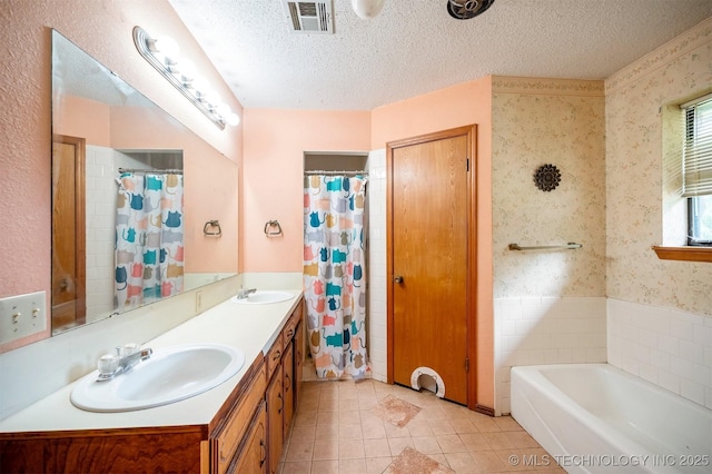 1001 E 1990th Rd, Soper, OK 74759 - bathroom featuring double vanity, tile patterned flooring, wallpapered walls, a garden tub, and a textured ceiling