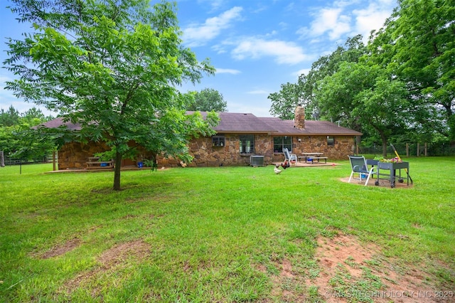 1001 E 1990th Rd, Soper, OK 74759 - back of property featuring stone siding, a chimney, a lawn, and a patio area