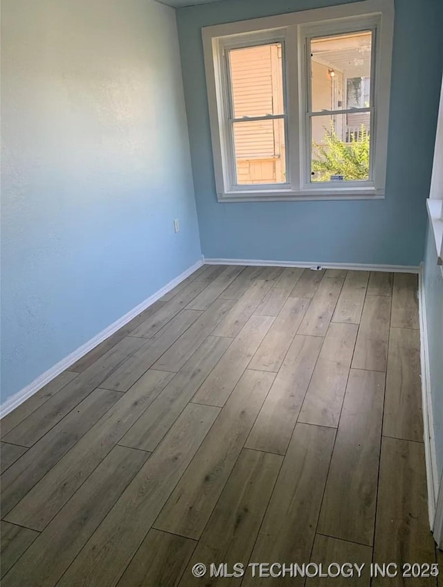 210 N G St, Muskogee, OK 74403 - unfurnished room featuring wood finished floors and baseboards