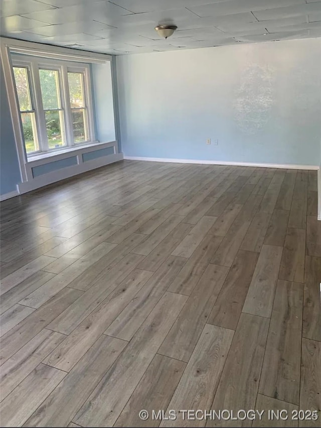 210 N G St, Muskogee, OK 74403 - spare room featuring wood finished floors and baseboards