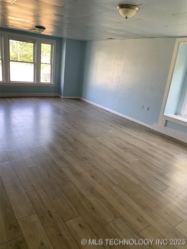 210 N G St, Muskogee, OK 74403 - spare room with dark wood-type flooring and baseboards