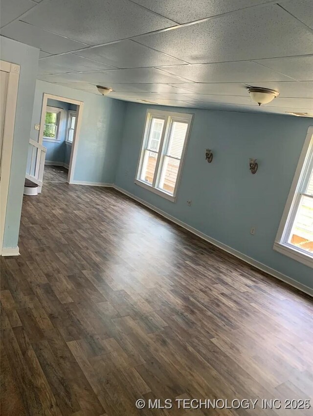 210 N G St, Muskogee, OK 74403 - empty room with healthy amount of natural light, dark wood-style flooring, and a paneled ceiling