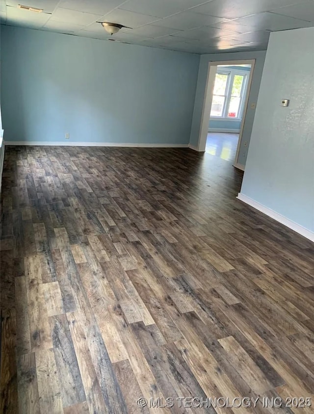 210 N G St, Muskogee, OK 74403 - empty room featuring dark wood-style floors and a paneled ceiling