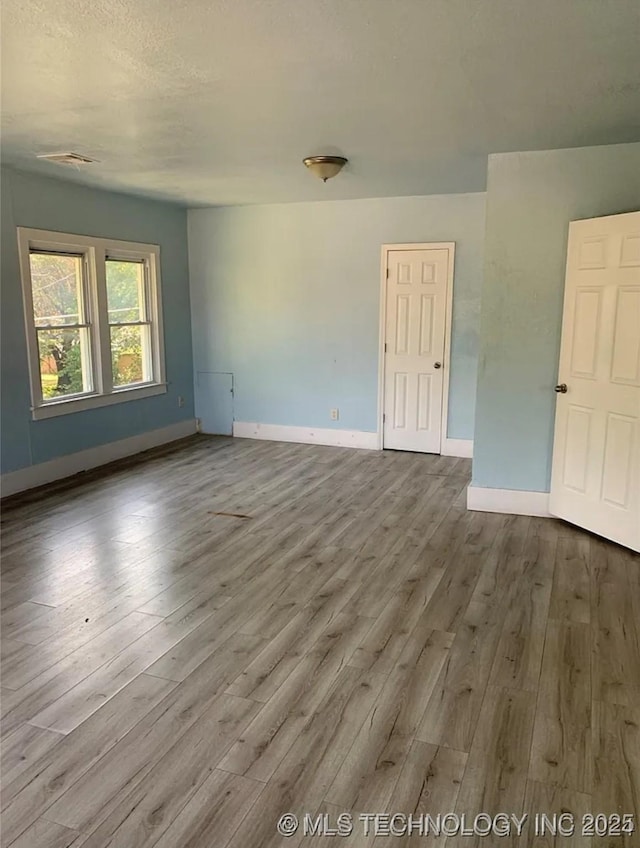 210 N G St, Muskogee, OK 74403 - empty room with wood finished floors and baseboards