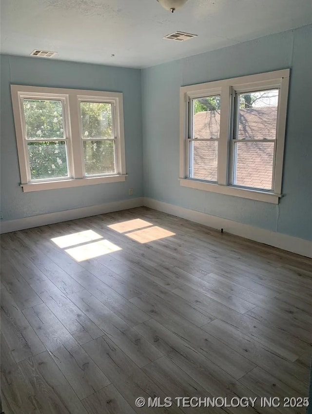 210 N G St, Muskogee, OK 74403 - unfurnished room featuring healthy amount of natural light and hardwood / wood-style flooring