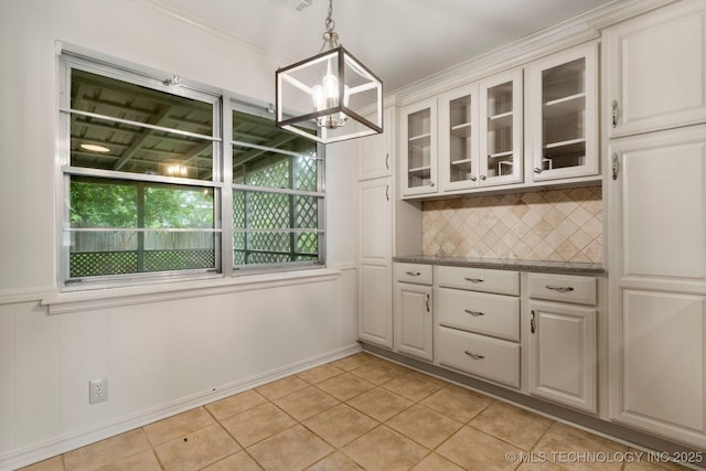 6725 E 51st Pl S, Tulsa, OK 74145 - unfurnished dining area with a chandelier, light tile patterned flooring, healthy amount of natural light, and crown molding