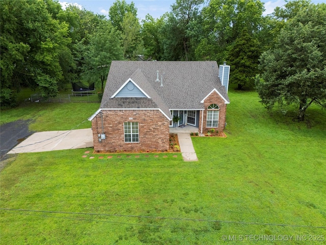 704 NE 3rd St, Wagoner, OK 74467 - traditional-style house with brick siding, a chimney, a front yard, and a shingled roof
