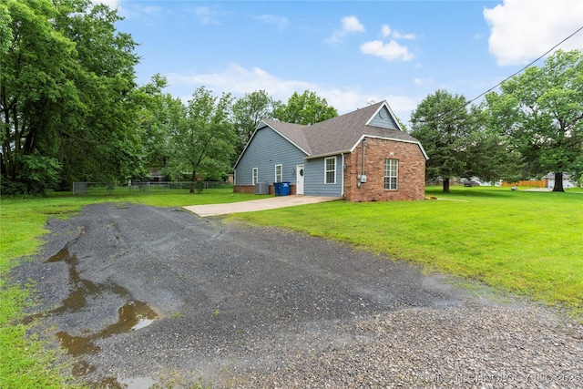 704 NE 3rd St, Wagoner, OK 74467 - view of side of home featuring brick siding, driveway, and a shingled roof