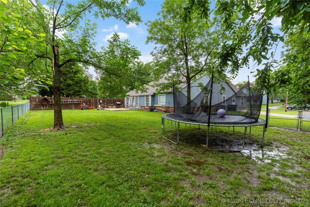 704 NE 3rd St, Wagoner, OK 74467 - fenced backyard featuring a trampoline