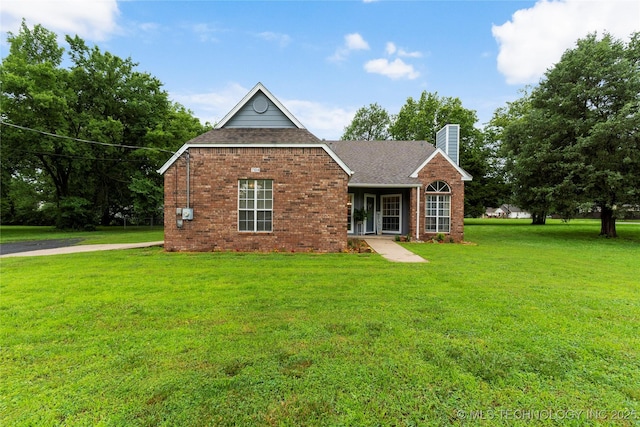 704 NE 3rd St, Wagoner, OK 74467 - view of front of house with a chimney, a front lawn, a shingled roof, and brick siding