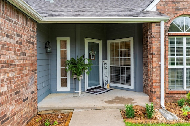 704 NE 3rd St, Wagoner, OK 74467 - entrance to property with a shingled roof, brick siding, and covered porch