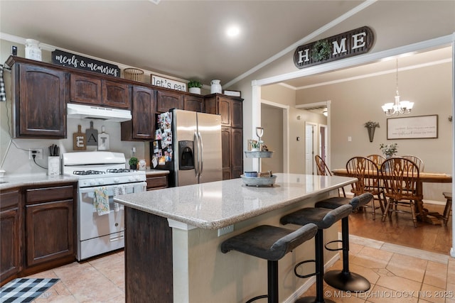 704 NE 3rd St, Wagoner, OK 74467 - kitchen with white gas range oven, stainless steel fridge, under cabinet range hood, a kitchen bar, and crown molding