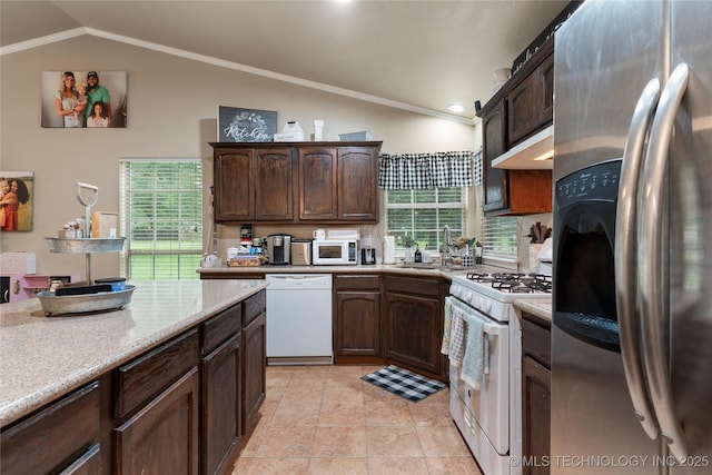 704 NE 3rd St, Wagoner, OK 74467 - kitchen with white appliances, under cabinet range hood, dark brown cabinets, crown molding, and high vaulted ceiling