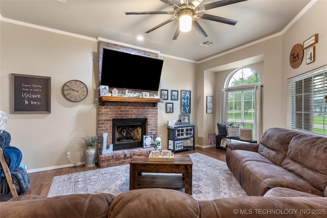 704 NE 3rd St, Wagoner, OK 74467 - living area featuring wood finished floors, ceiling fan, ornamental molding, and a brick fireplace