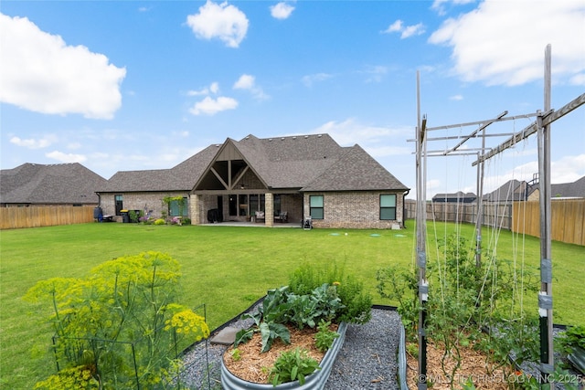 17831 S 46th E Ave, Bixby, OK 74008 - back of house featuring a vegetable garden, a fenced backyard, roof with shingles, a patio, and brick siding