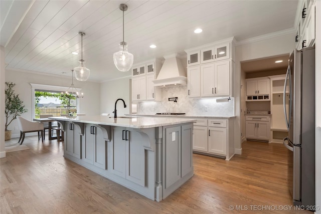 17831 S 46th E Ave, Bixby, OK 74008 - kitchen with freestanding refrigerator, custom exhaust hood, crown molding, an island with sink, and tasteful backsplash