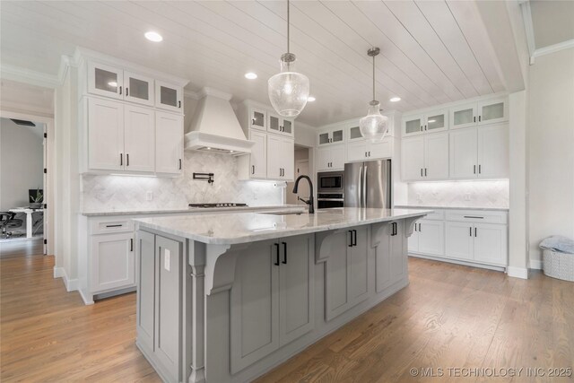 17831 S 46th E Ave, Bixby, OK 74008 - kitchen with appliances with stainless steel finishes, custom exhaust hood, a center island with sink, recessed lighting, and backsplash