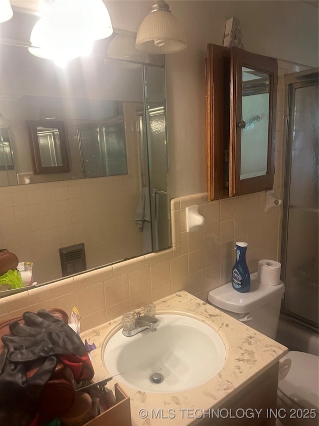 320 E Mckinley Ave, Sapulpa, OK 74066 - full bathroom with a shower with shower door, vanity, tasteful backsplash, and tile walls